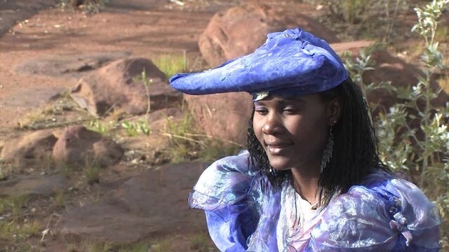 herero woman wearing a Victorian style dress outdoors in a village in north Botswana