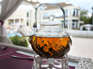 glass teapot with exotic green tea on table