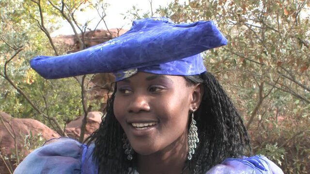 herero woman wearing a Victorian style dress outdoors in a village in north Botswana