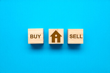 Wooden cubes with the words BUY, SELL and the drawing of a house