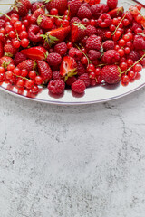 Fresh summer fruit composition. Strawberries, red currants, raspberries placed on metal tray
