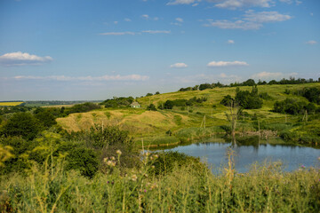Fototapeta na wymiar Village landscape with lake and blue sky