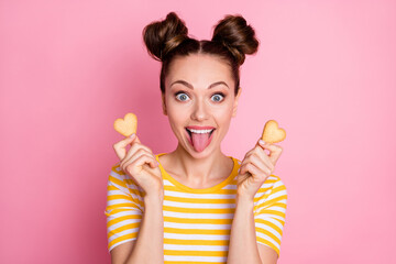 Close-up portrait of her she nice-looking attractive pretty comic childish funky cheerful cheery teenage girl holding in hand heart cookies grimacing having fun isolated pink pastel color background