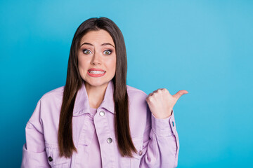 Dont look there. Portrait of nervous anxious girl point thumb finger copyspace frightened corona virus terrible novelty wear good look clothes isolated over blue color background