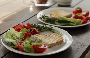 Healthy organic vegetable breakfast, tomato toast salad basil cucumber arugula
