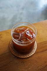 Close up glass of iced black Americano coffee on wooden tray table
