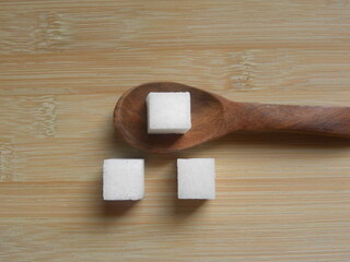 White color granulated Sugar cube on wooden spoon