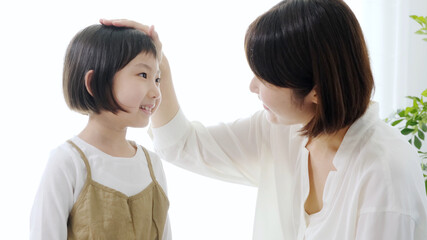 子どもの頭を撫でるお母さん