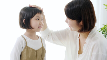 子どもの頭を撫でるお母さん