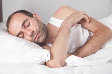 Caucasian man sleeping in bed.