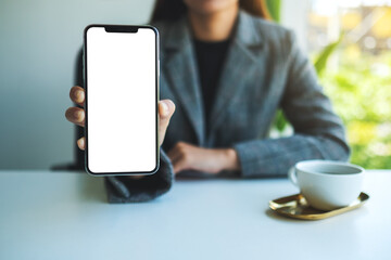 Mockup image of a businesswoman holding and showing mobile phone with blank white screen