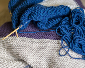 Fototapeta na wymiar knitted sweater, knitting needles and yarn, close-up view