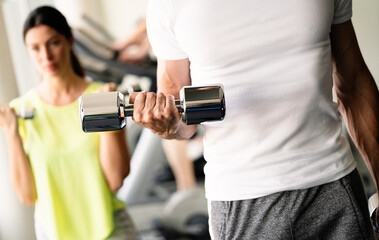 Sport, fitness, lifestyle and people concept. Group of happy poeple with dumbbells in gym