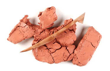 Red modelling clay chunks with spatula, sculpting knife isolated on white background, top view