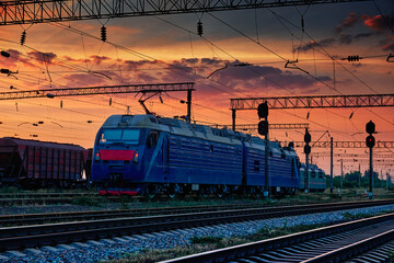 Fototapeta na wymiar railway train and rail cars in a beautiful sunset, dramatic sky and sunlight