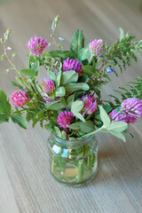 Bouquet of clover flowers in a vase. Rustic still life with clover wildflowers. Natural still life. Selective soft focus