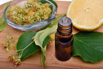 Fresh healthy linden flowers, lemon and tea with essential oil on a white background