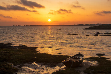 Fishing boat on the beach at sunset