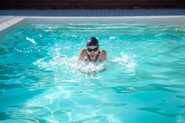 Swimmer in pool head above water hands in front
