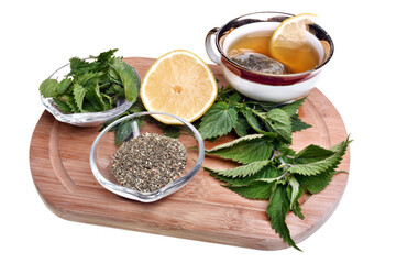 Fresh healthy nettle plant, dried herbs and hot tea