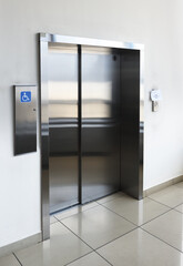 disabled signage, Modern steel elevator cabins in a business lobby or Hotel, Store, interior, office,perspective wide angle.	