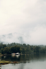 Altai nature at dawn in the fog. Haze in the forest and on the lake, atmospheric weather for the screensaver.