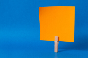 paper notes and clothespins isolated on orange background
