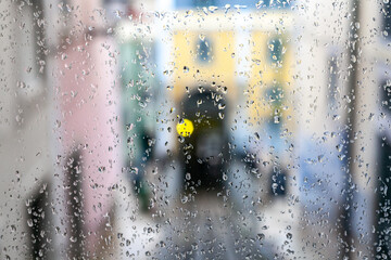 Vista de una calle de Lisboa a través de un cristal mojado en un día de lluvia.