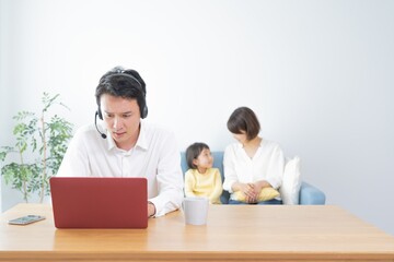 Fototapeta premium 親子 三人 テレワークをする父親 ポートレート