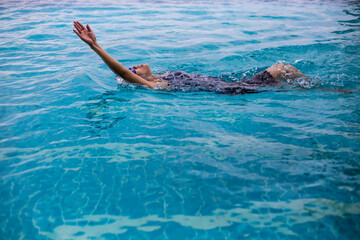 Female swimmer with backstroke action at the swimming pool