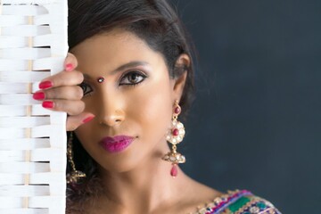 Face close up image of young beautiful Indian woman wearing Saree.