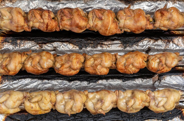 series of grilled chickens on a roasting pan