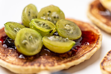 
Tasty breakfast. Pancake with gooseberries and jam. Close-up.