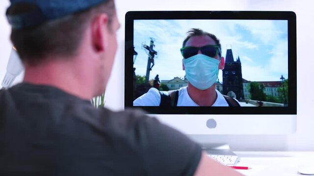 A man in a mask on his face calls a friend from a trip. Long distance exchange of emotions in self-isolation. Using an online video call.