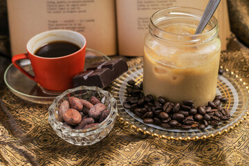 A cup of hot coffee and a ice coffee in jar