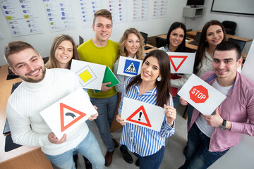 Students holding paper images of road traffic signs