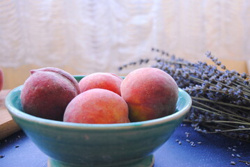 A bowl of fresh organic peaches served on the table as a healthy snack.