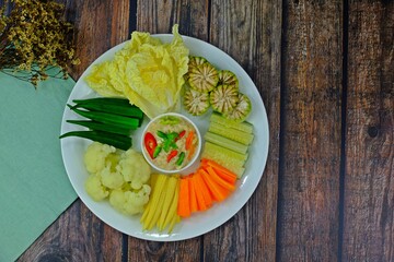 Preserved soy bean dip (Tao Jiaw Lone) Herbed soya beans with minced shrimp and pork in coconut milk served with fresh seasonal vegetables on wooden table. Authentic Thai food.