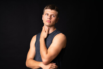 Naklejka premium Portrait of young man over isolated black background