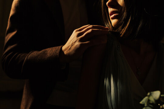Cropped image of beautiful young  couple. The husband gently hugs his wife, she is passionate. Close-up. Shadows on face.