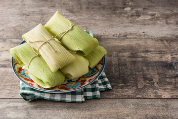 Mexican corn and chicken tamales on wooden table.Copy space	