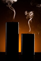 Burning black candle on dark