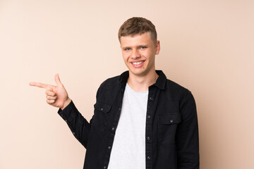 Young handsome man pointing finger to the side