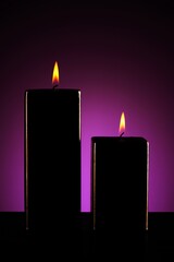 Burning black candle on dark