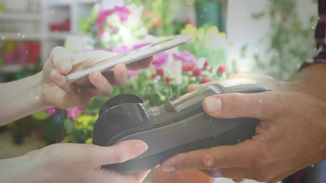 Animation of light circles floating over Caucasian woman paying with a smartphone