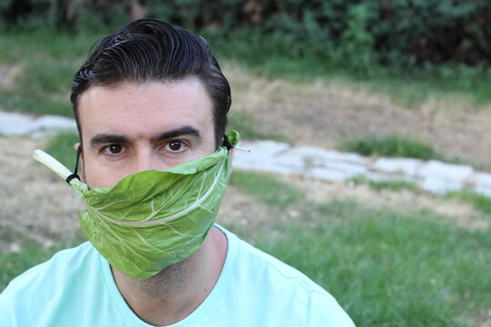 Man using lettuce as protective face mask 