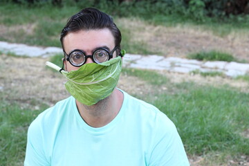 Man using lettuce as protective face mask 