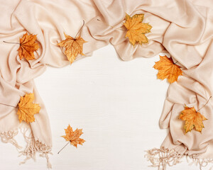 Yellow autumn leaves flat lay on white wooden background with copy space. Natural leaves of maple tree and cozy warm palantine, autumnal theme. Top view.