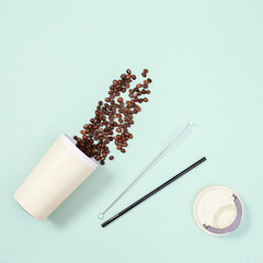 Metal drinking straws, bamboo coffee cup with roasted coffee beans. Zero waste concept.