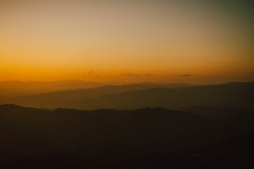 Obraz premium View of silhouatte of mountain range under the sky during the sunset. Beautiful evening nature background.